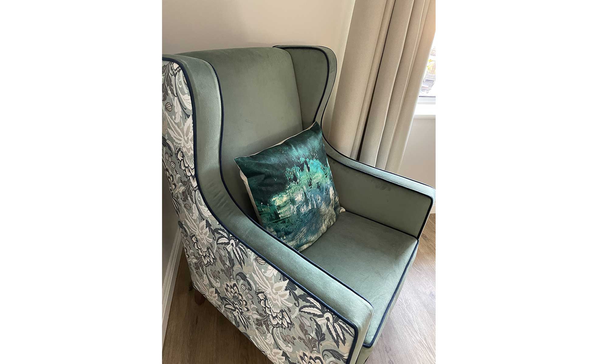 Orto Wing Back Chair in a bedroom with green cushion on the seat