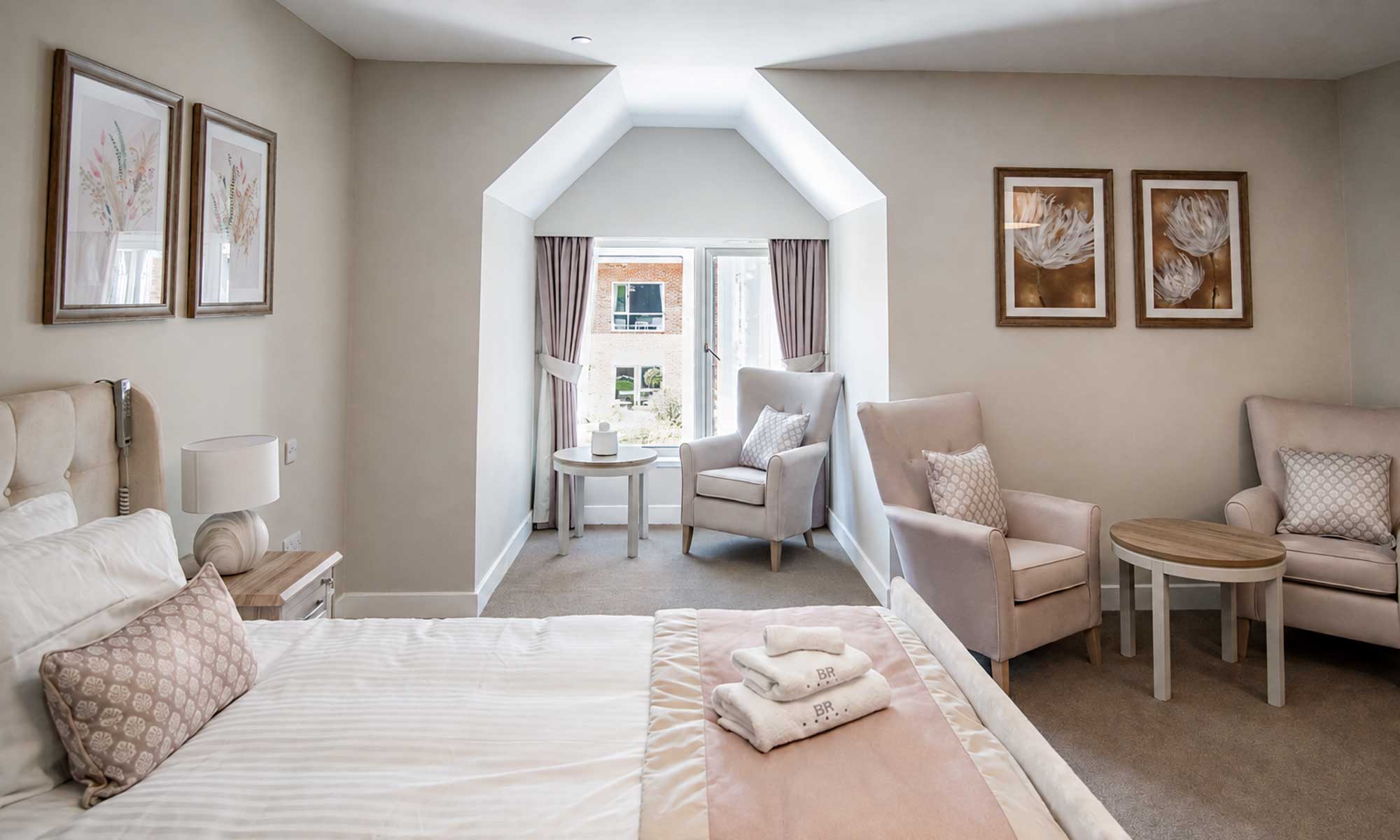 Luxury care home bedroom at Bellerose Manor with upholstered seating, bedside furniture, occasional tables and coordinated soft furnishings.