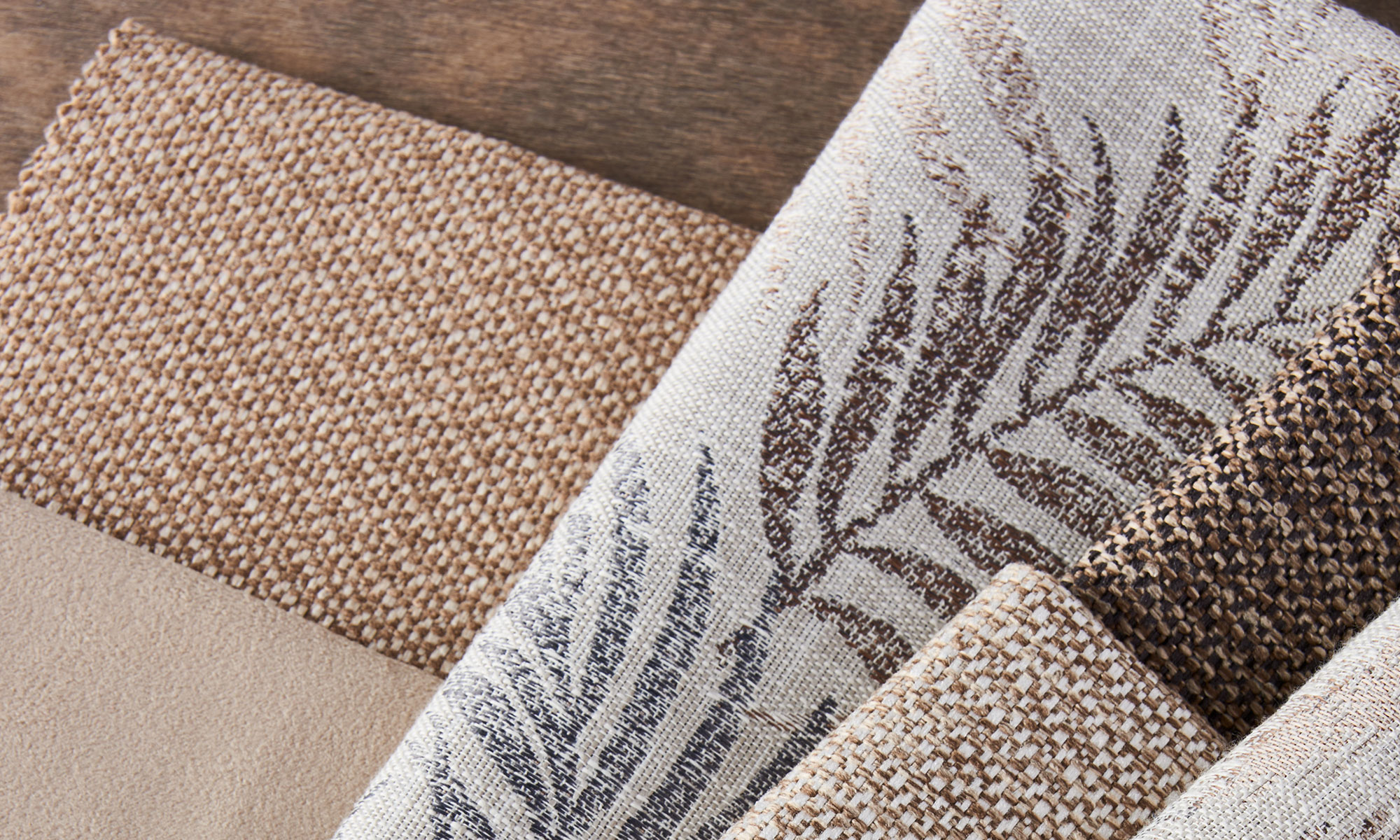 Close-up of coordinating neutral upholstery fabrics with woven and abstract patterns.